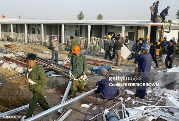 Construction workers put the finishing touches on a newly built hospital for SARS patients, 29 April 2003, in Xiaotangshan, on the outskirts of...