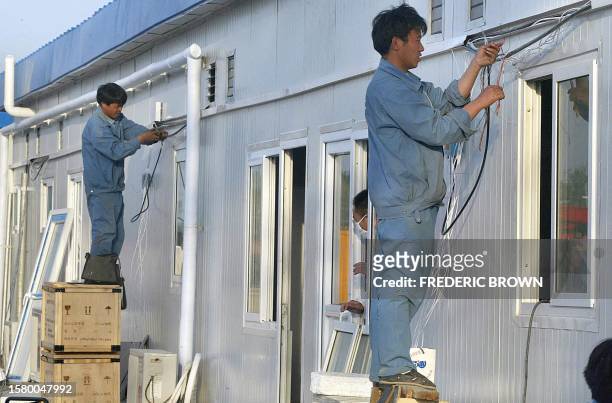 Construction workers put the finishing touches on a newly built hospital for SARS patients, 29 April 2003, in Xiaotangshan on the outskirts of...
