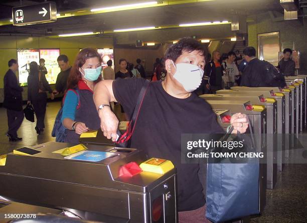 Commuters enter the train station in Wanchia Hong Kong, 27 March 2003, where one of the train station staff contracted atypical pneumonia according...