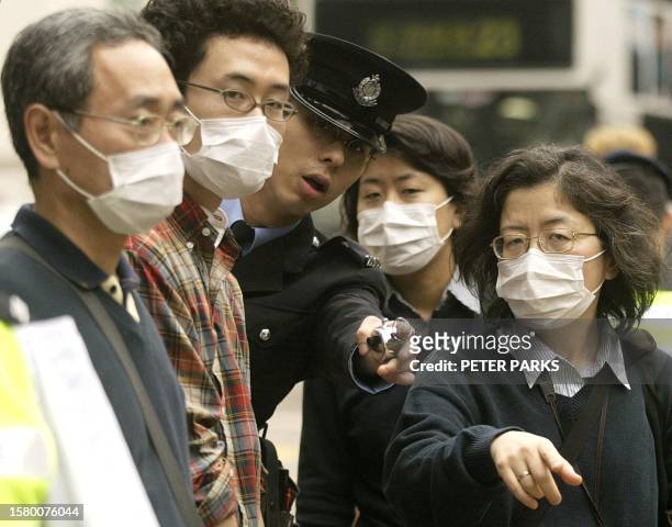 Policeman gives directions in Central Hong Kong to four tourists wearing masks to protect themselves from a global outbreak of pneumonia which has so...
