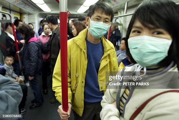 Couple wear masks on Hong Kong's Mass Transit Railway to protect themselves from a global outbreak of pneumonia which has so far killed 12 people...