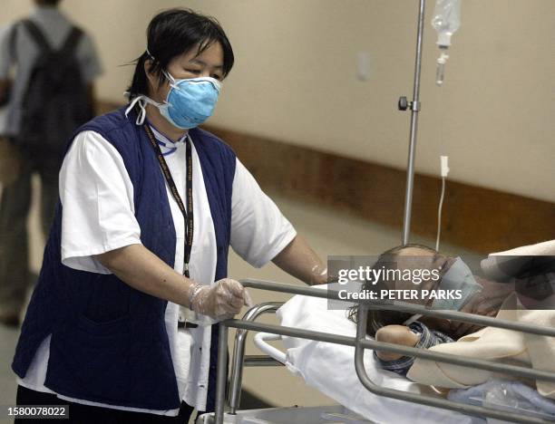 Patient and staff member wear masks at the Prince of Wales Hospital in Hong Kong, 17 March 2003, to protect against a mysterious outbreak of...