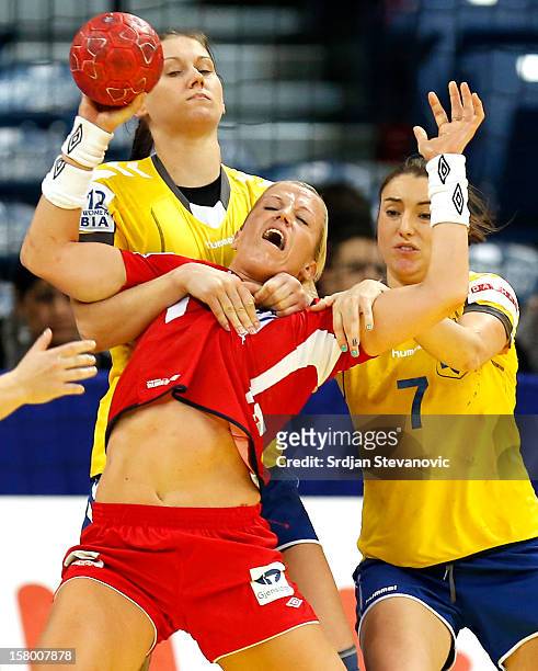 Heidi Loke of Norway is challenged by Viktoriya Borshchenko and Olga Laiuk of Ukraine during the Women's European Handball Championship 2012 Group A...
