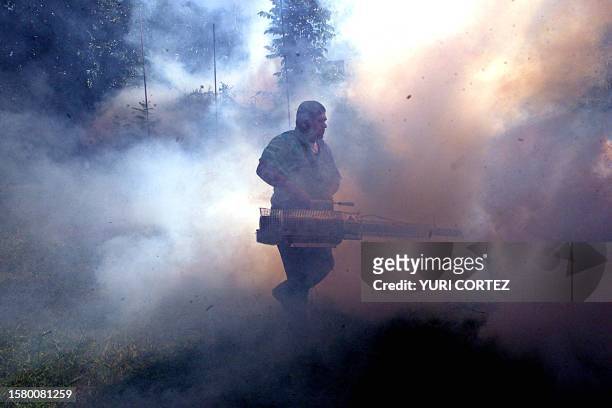 An employee of the Salvadorean Social Security fumigates, 21 June 2002, during an intense campaign to erradicate the "Aedes Aegypti" mosquito that...
