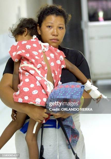 An unidentified woman carries her daughter who is infected with dengue, while waiting to be attended in the pediatric unit of the Maternal Hospital...