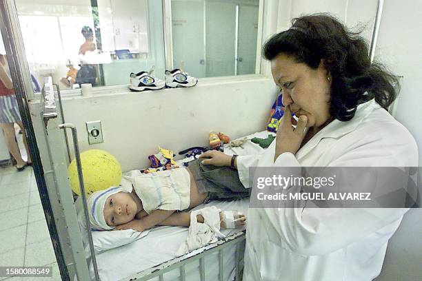 Eleonora Navas is seen trying to lower the fever of a child in Managua, Nicaragua 13 November 2001. Eleonora Navas , jefa de servicios medicos del...