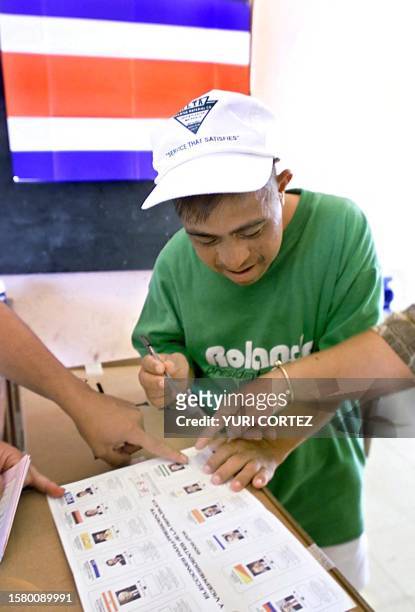 Child with Down Syndrome helps mark election tickets during the elections in San Jose, Costa Rica, 03 February 2002 . Un joven con sindrome de Down...