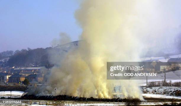 Smoke covers nearby appartment blocks as some 300 cattle and 400 sheep infected with foot-and-mouth disease are being incinerated on a field at...