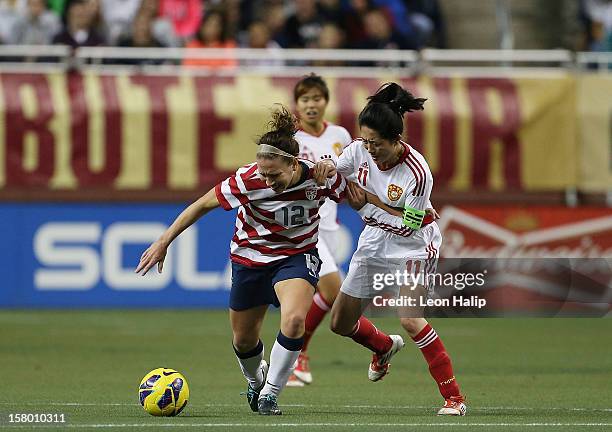 Lauren Cheney of Team USA centers the ball around Wei Pu of China during the first half of the game Ford Field on December 8, 2012 in Detroit,...