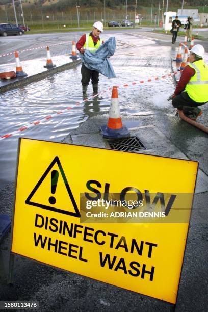 Eurotunnel employees replenish a disinfectant wheel dip for trucks bound for France on the cross-channel train 02 March 2001. Eurotunnel is...