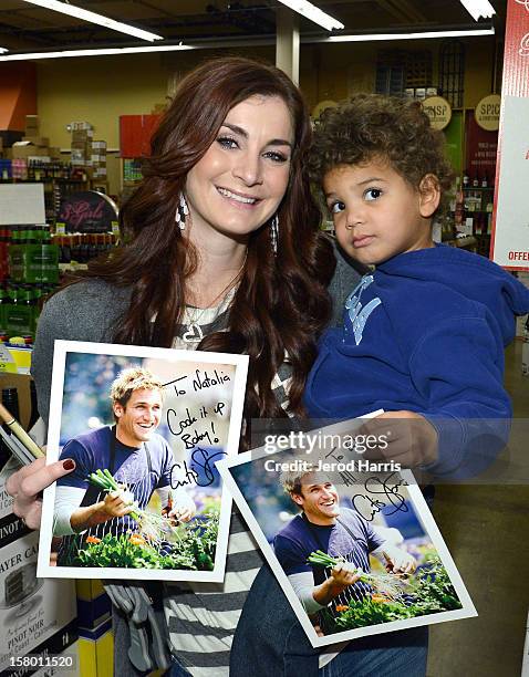 Natalia Simmons and son Eli Simmons show off their autographed pictures of Celebrity Chef Curtis Stone at Cost Plus World Market's Share the Joy...