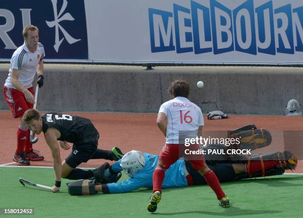 Simon Child of New Zealand gets the ball past keeper George Pinner of England during their match at the men's Hockey Champions Trophy tournament in...