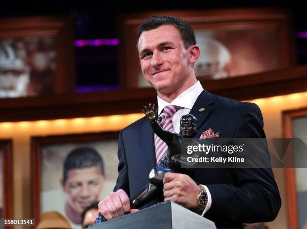 Quarterback Johnny Manziel of the Texas A&M University Aggies poses with the Heisman Memorial Trophy after being named the 78th Heisman Memorial...