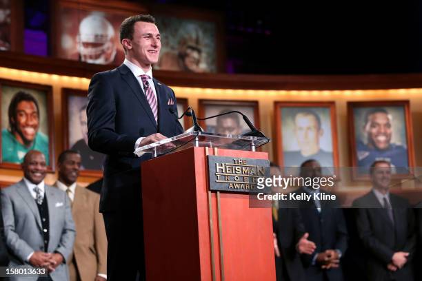 Quarterback Johnny Manziel of the Texas A&M University Aggies poses with the Heisman Memorial Trophy after being named the 78th Heisman Memorial...
