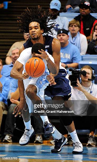 Dexter Strickland of the North Carolina Tar Heels takes a loose ball away from Hunter Harris of the East Tennessee State Buccaneers during play at...