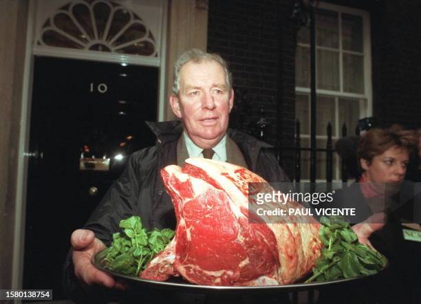 David Cray of the British National Cattle Association carries a beef rib joint to No. 10 Downing Street 15 December in protest of a ban in Britain on...