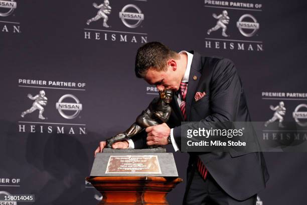 Quarterback Johnny Manziel of the Texas A&M University Aggies kisses the Heisman Memorial Trophy after being named the 78th Heisman Memorial Trophy...