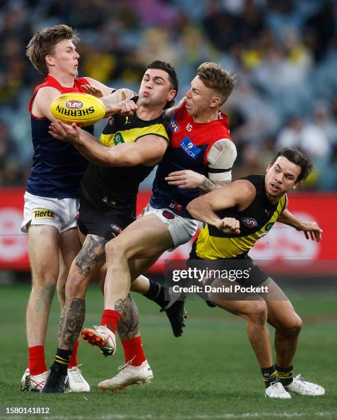 Tim Taranto of the Tigers contests the ball against James Harmes of the Demons and James Jordon of the Demons during the round 20 AFL match between...