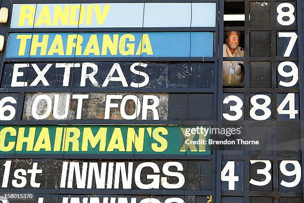 Scoreboard operator watches play during an international tour match between the Chairman's XI and Sri Lanka from inside The Jack Fingleton Scoreboard...