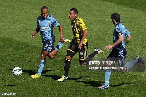 Leo Bertos of the Phoenix runs the ball under pressure from Fabio and Terry McFlynn of Sydney FC during the round 10 A-League match between...