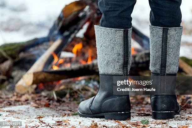 Man warms hismelf next to a camp fire after choosing and cutting down his Christmas tree in a forest on on December 8, 2012 in Fischbach, Germany....