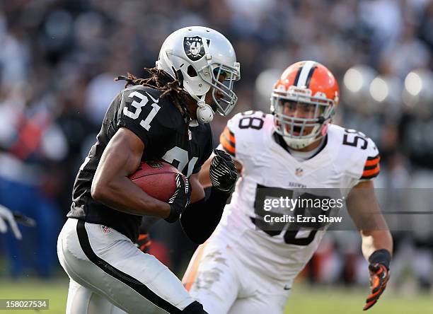 Coye Francies of the Oakland Raiders runs by L.J. Fort of the Cleveland Browns at O.co Coliseum on December 2, 2012 in Oakland, California.