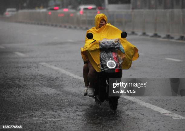 Citizen rides in a rain on July 30, 2023 in Beijing, China. Beijing on the evening of July 29 issued a red alert for rainstorms. Heavy rains brought...