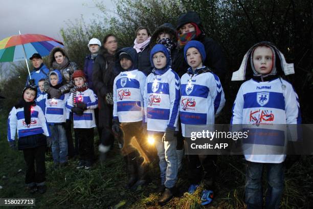 Members of the Dutch football club SC Buitenboys take part in a silent march on December 9, 2012 in Almere, to pay their respects to their late...