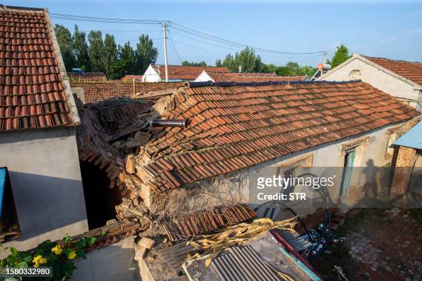 House with a damaged roof is seen in Pingyuan county, Dezhou city, in China's eastern Shandong province, on August 6 following a 5.4-magnitude...
