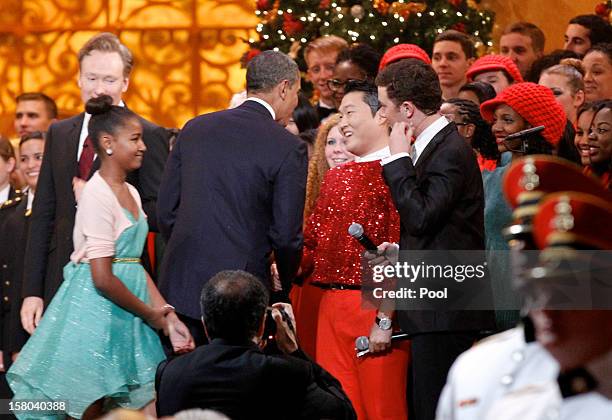 President Barack Obama shakes hands with South Korean musician PSY , next to host Conan O'Brien and performer Scotty McCreery during the "Christmas...