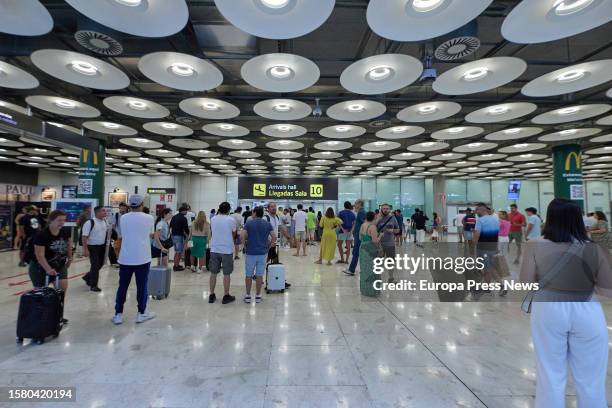 Several people wait in the arrivals hall of Terminal 4 at Adolfo Suarez Madrid-Barajas Airport, on August 1 in Madrid, Spain. Aena's airport network...