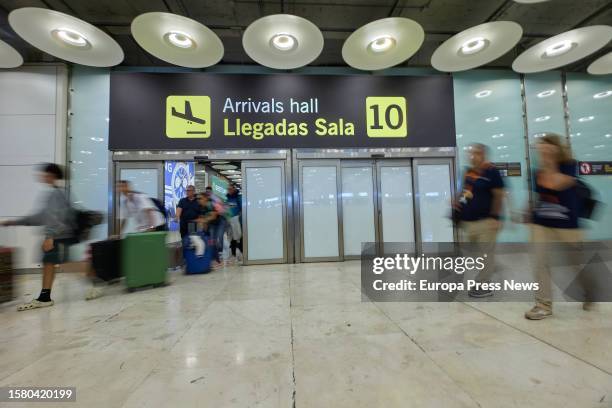 Several passengers leave with their suitcases in arrivals hall 10 of Terminal 4 at Adolfo Suarez Madrid-Barajas Airport, on August 1 in Madrid,...