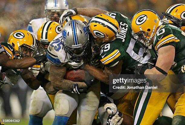 Mikel Leshoure of the Detroit Lions is gang-tackled by members of the Green Bay Packer defense including Brad Jones and A.J. Hawk at Lambeau Field on...