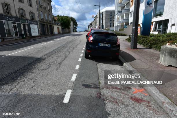 This photograph taken on August 6 shows traces of blood and a painted X representing the location of a body of one of the two men killed in an...