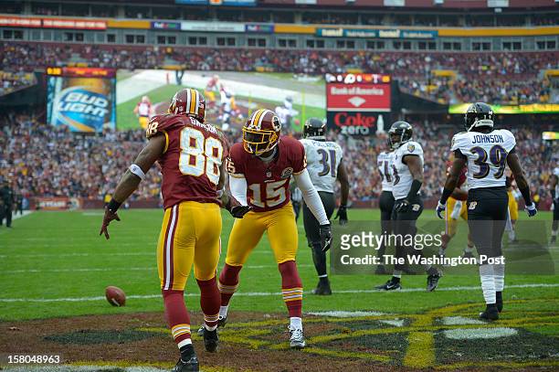 Washington's wide receiver Josh Morgan is congratulated by Washington's wide receiver Pierre Garcon after catching a pass for a touchdown early in...