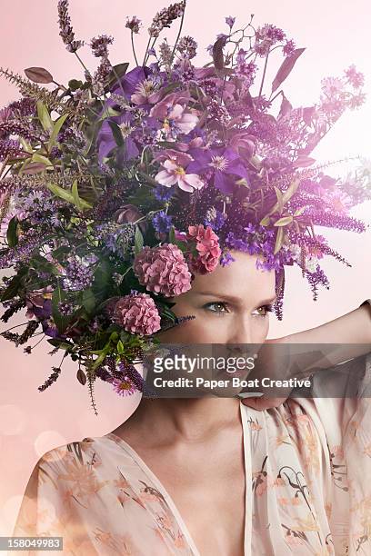 lady wearing a big purple hat made of flowers - adorno floral fotografías e imágenes de stock