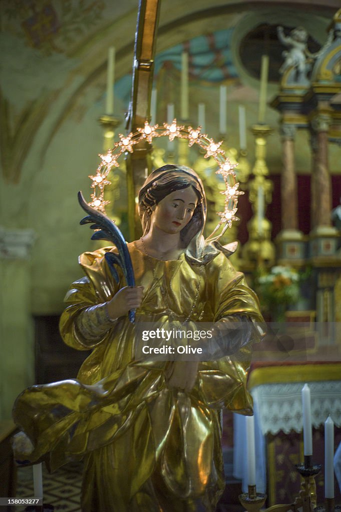 Statue of blessed virgin in church with lighting h