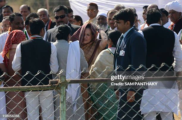 Congress President, Sonia Gandhi adjusts her saree as she greets Congress party leaders during a political rally ahead of the Gujarat Assembly polls...