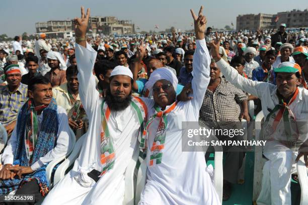 Muslim and a Hindu Congress party supporter make the victory sign during a political rally addressed by Congress president Sonia Gandhi ahead of the...