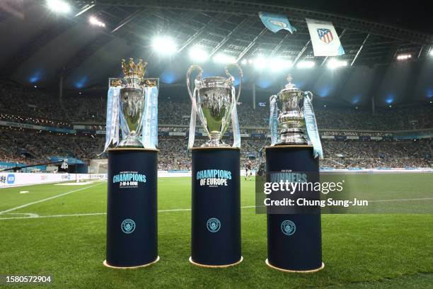 The Premier League trophy, Champions League trophy and FA Cup trophy are seen next to the pitch prior to the preseason friendly match between...