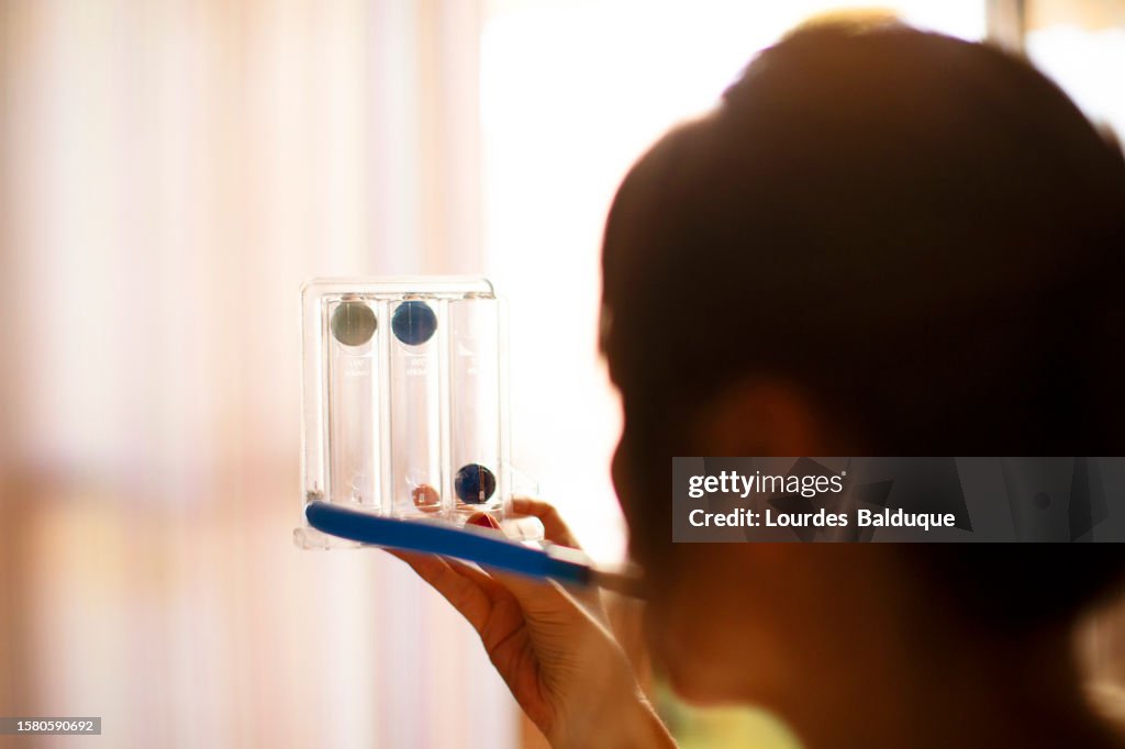 Woman using spirometer