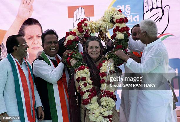 Congress President, Sonia Gandhi smiles as she is garlanded by Congress Party leaders during a Congress Party rally ahead of the Gujarat Assembly...