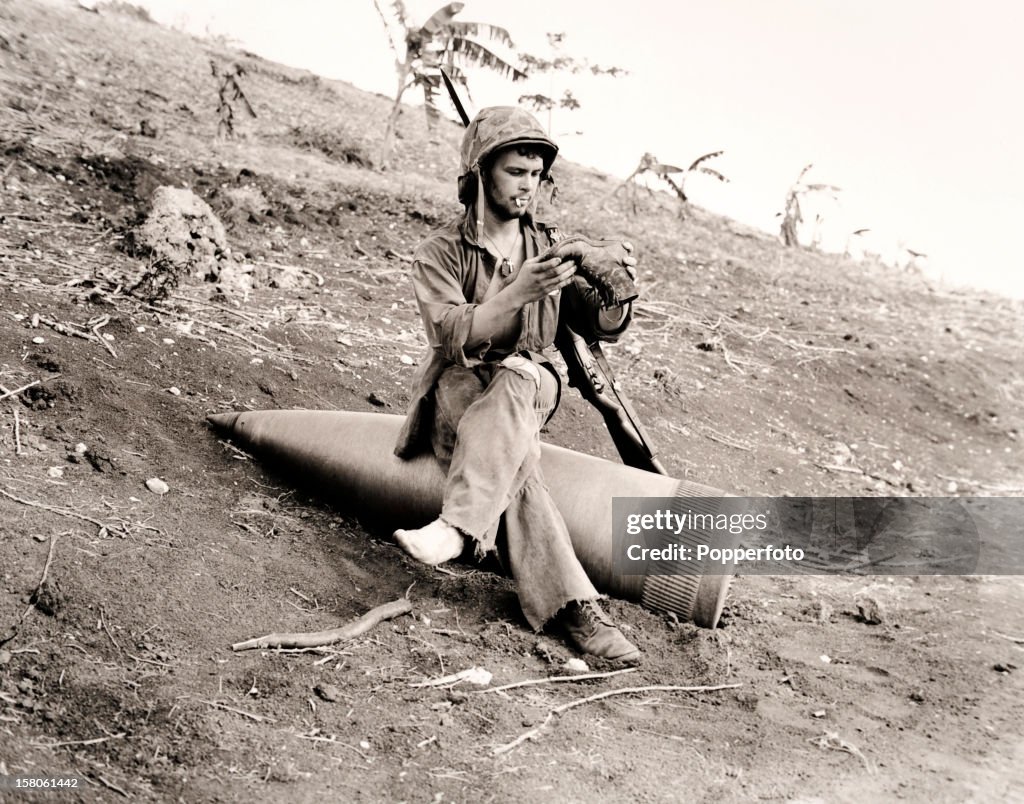 Shell Injuries Ww2 An American serviceman examines his boot using an unexploded shell ...