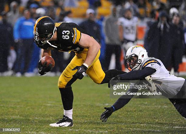 Tight end Heath Miller of the Pittsburgh Steelers avoids a tackle by safety Corey Lynch of the San Diego Chargers as rain falls during a game at...