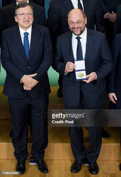 President of the European Parliament Martin Schulz holds the medal of the Nobel Peace Prize as he poses with President of the European Commission...