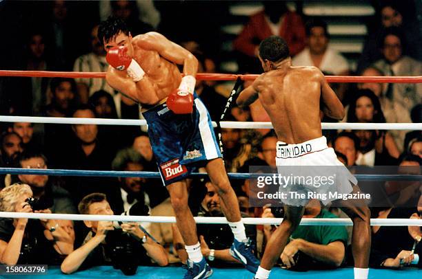 Oscar De La Hoya is hit with a left punch from Felix Trinidad during the fight at the Mandalay Bay Resort & Casino,on September 18,1999 in Las Vegas,...