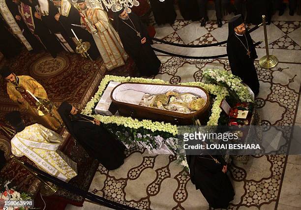 Greek Orthodox priests stand around the coffin of Greek Orthodox patriarch of Syria, Ignatius IV Hazim, during his funeral at the Meriamiah Church in...