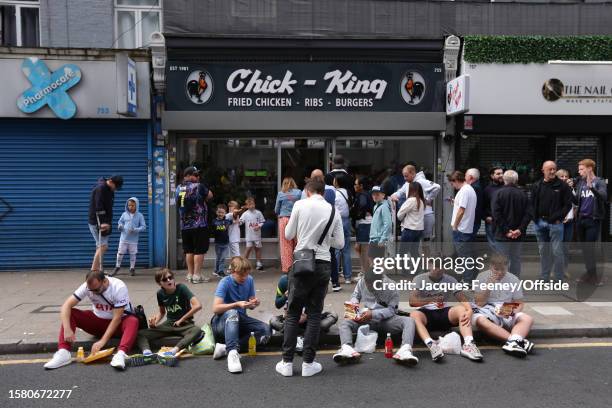 Fans eat food on the road outside the stadium during the pre-season friendly match between Tottenham Hotspur and Shakhtar Donetsk at Tottenham...