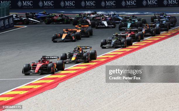 Charles Leclerc of Monaco driving the Ferrari SF-23 leads Sergio Perez of Mexico driving the Oracle Red Bull Racing RB19 and the rest of the field at...