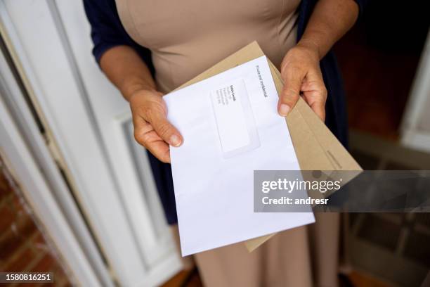 nahaufnahme einer frau an der haustür ihres hauses, die ihre post hält - mail stock-fotos und bilder